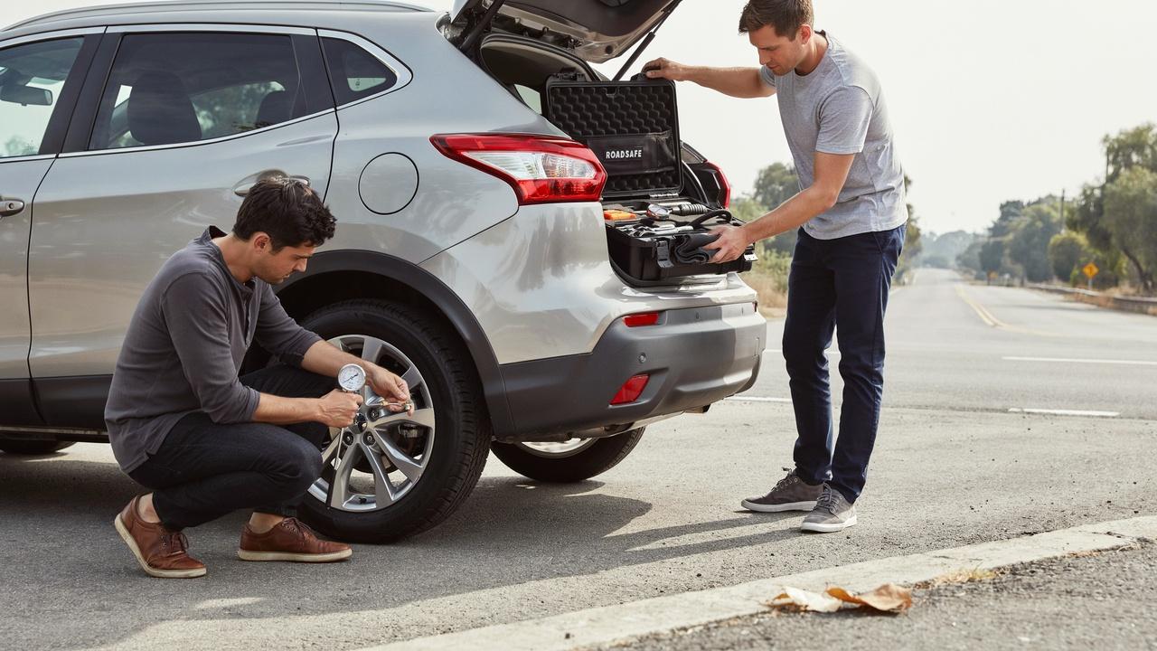 Checking tire pressure and storing tools after tire change.