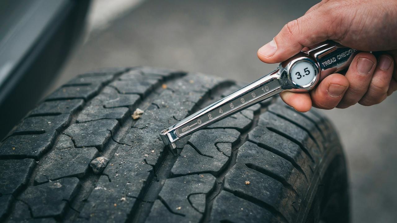 Comparing tire tread depth measurements with recommended levels.