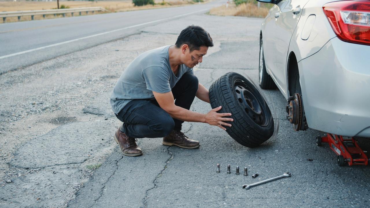 Removing flat tire from vehicle wheel hub.
