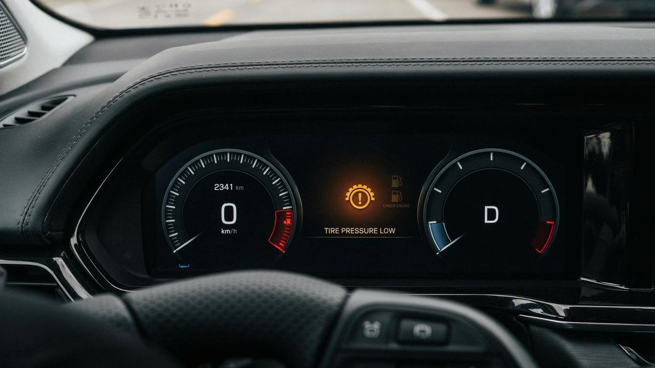 Close-up of a vehicle dashboard displaying the tire pressure monitoring system warning light.