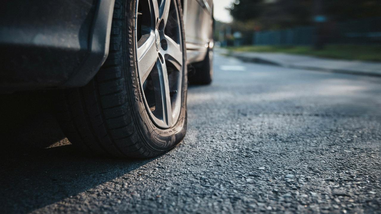 Car driving slowly on flat tire showing sidewall damage risk.