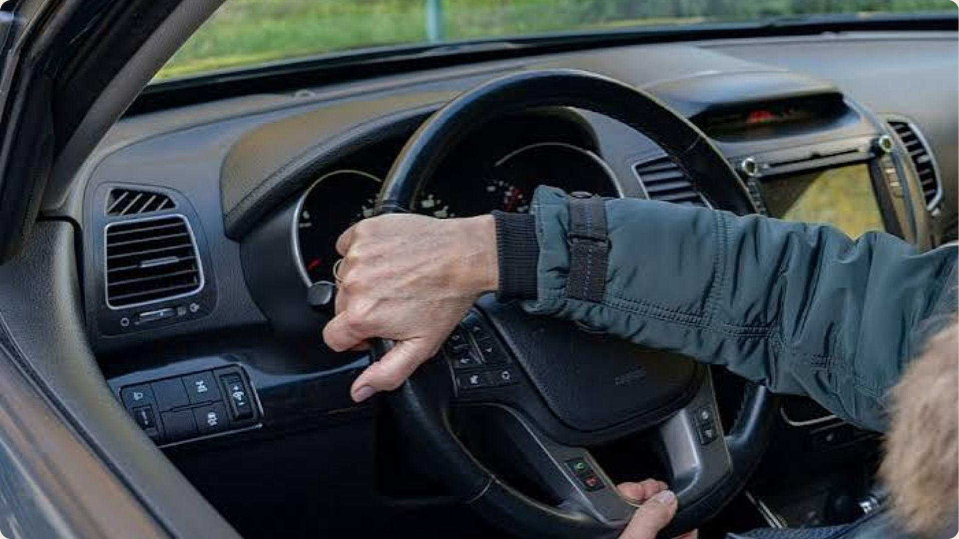 A driver holds the steering wheel, navigating the vehicle with concentration.