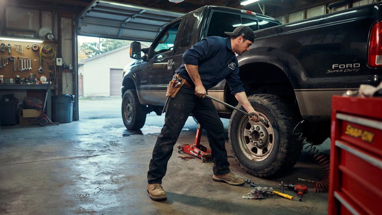 Loosening lug nuts and lifting a dually truck for tire rotation.