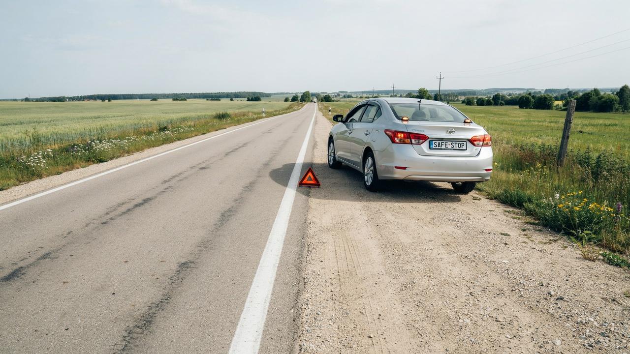 Car safely parked on a flat roadside before changing tire.