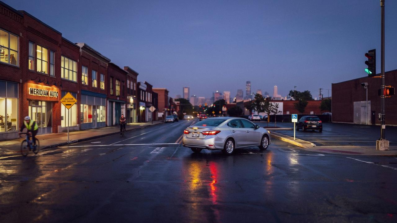 Car driving slowly with hazard lights toward a safe stopping area.