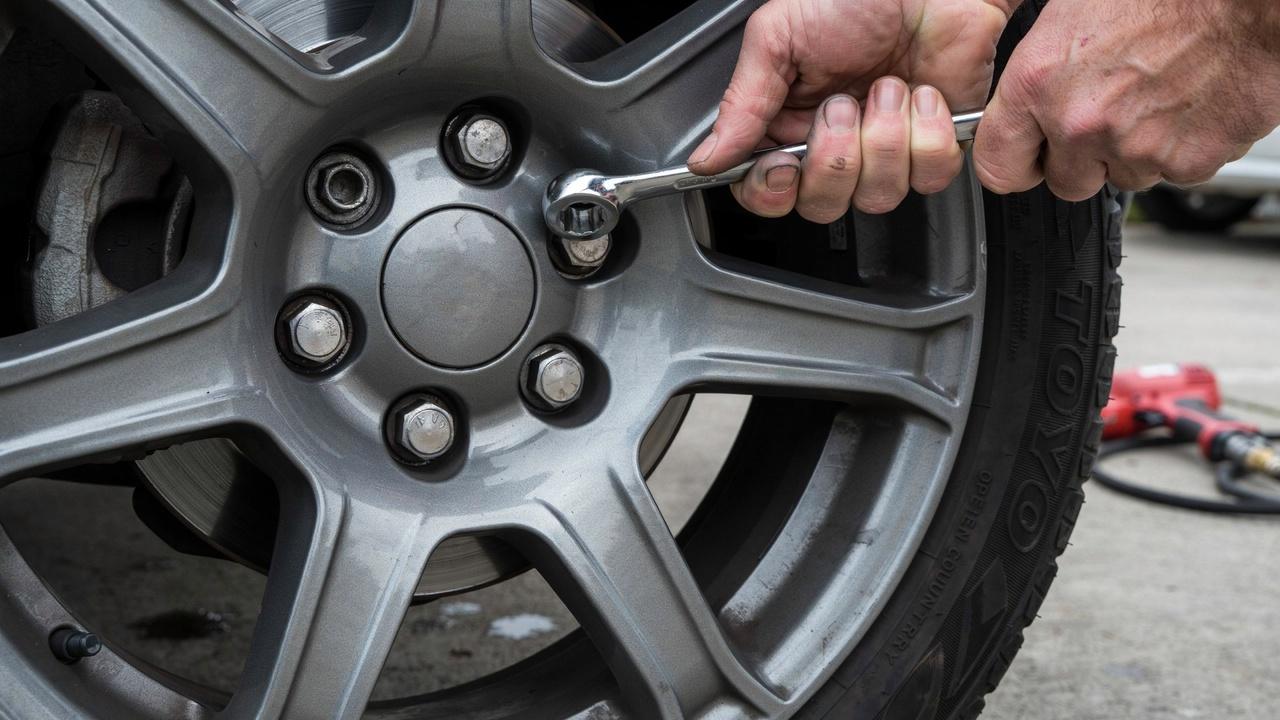 Fully tightening lug nuts after lowering the car.