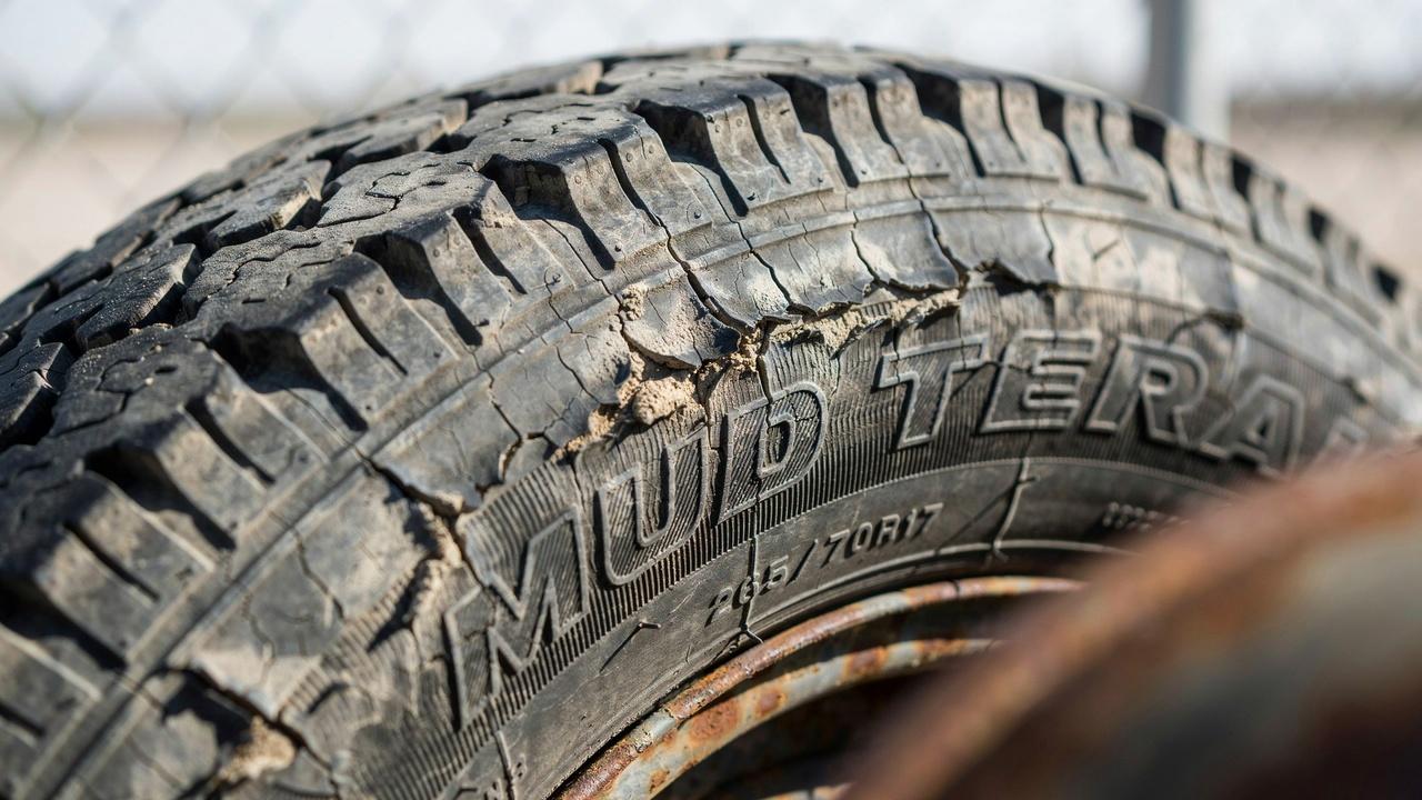 Worn-out tire showing cracks and aging damage.