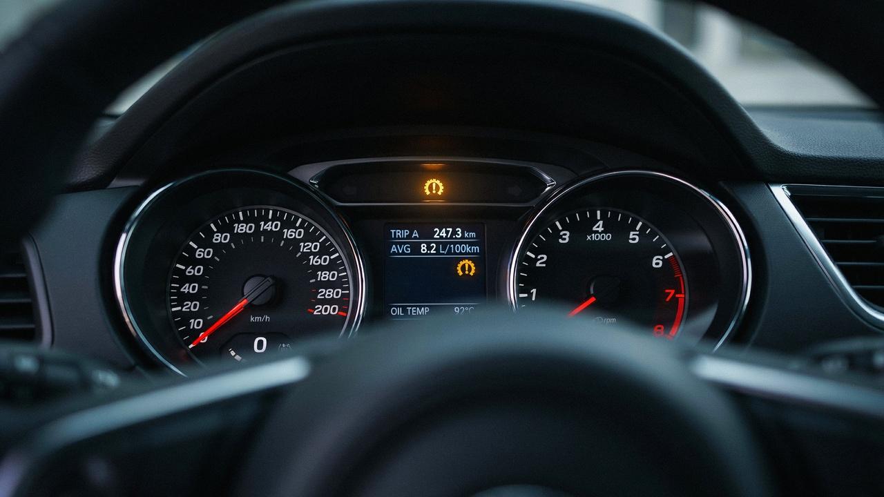 Close-up of a dashboard displaying a flashing tire pressure warning light.